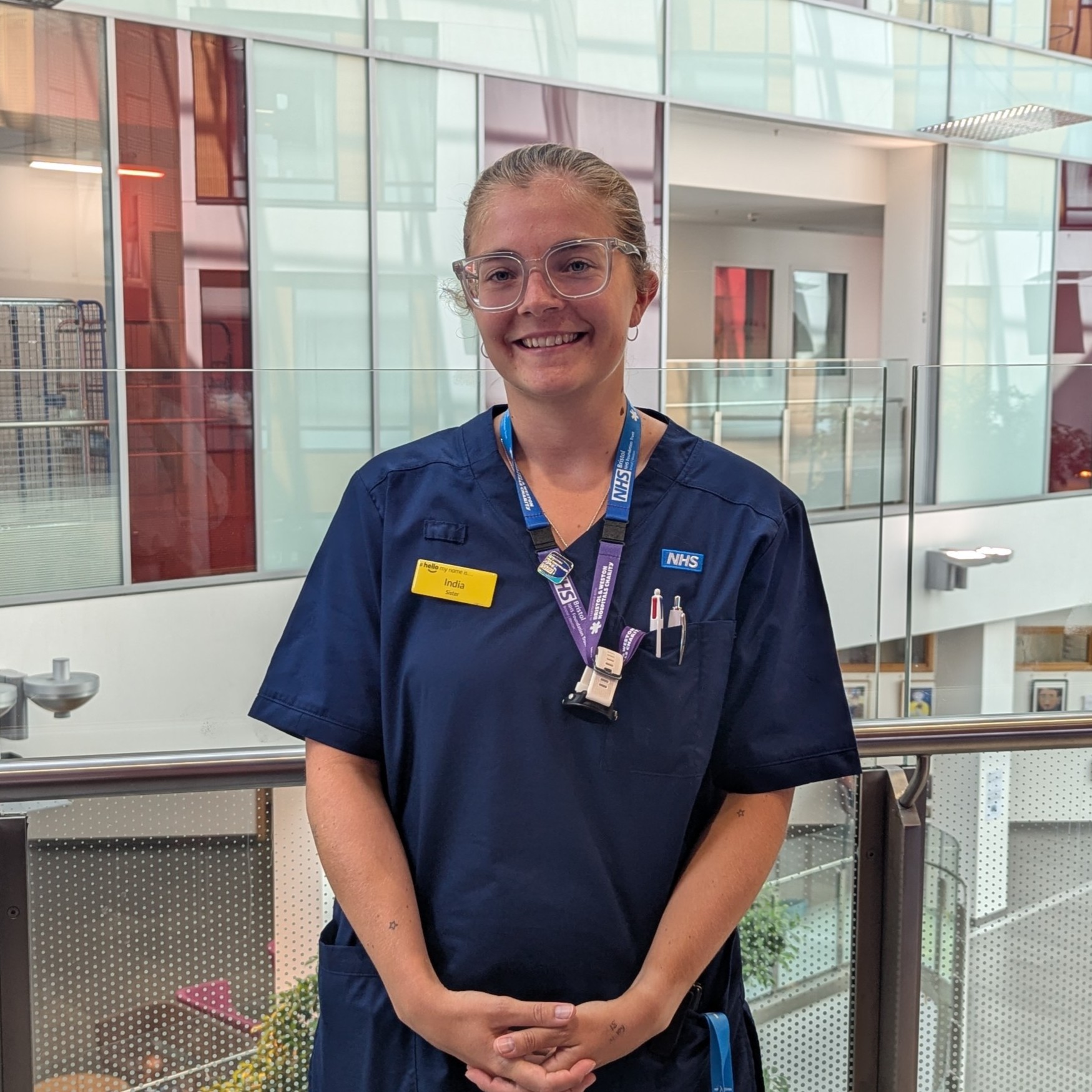 India in uniform pictured in the Brunel Building atrium smiling.