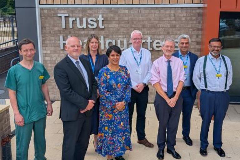 Group photo of Professor Meghana Pandit and Dr Trevor Smith with North Bristol Trust colleagues outside trust headquarters