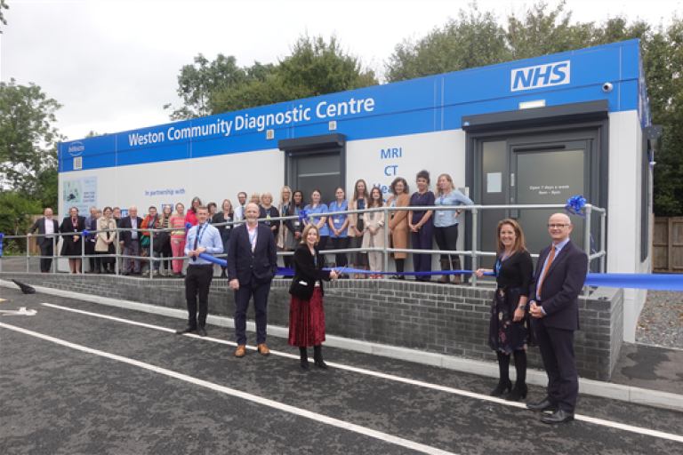 Staff pose outside Weston Community Diagnostic Centre for the ribbon cutting, with balloons
