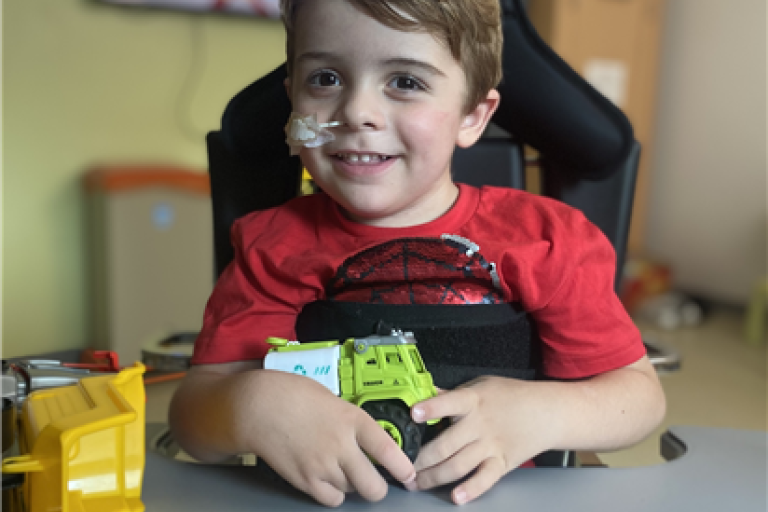 Freddie smiling while playing with toy trucks