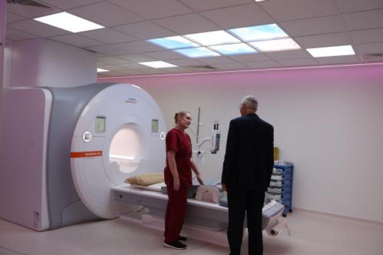 Two medical professionals standing in front of a MRI scanner