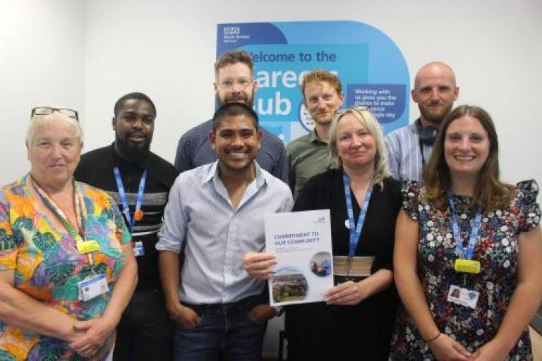 "Commitment to Our Community" team smile for group photo at launch event
