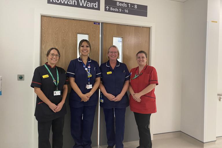 Four healthcare professionals smile outside Rowan Ward