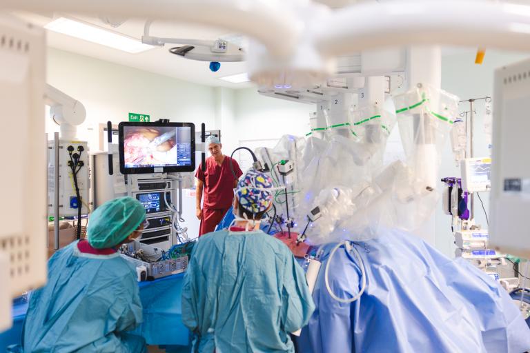Rt Hon Peter Kyle MP in surgical theatre with medical team operating on patient with the surgical robot