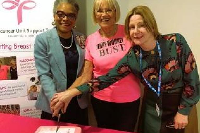 Mrs Peaches Golding OBE, Jenny Wookey, and Maria Kane pose cutting the BUST thank you cake