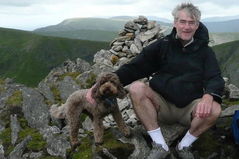 Duncan, who volunteered for the Nova trial, sits on a dry stone wall with his dog