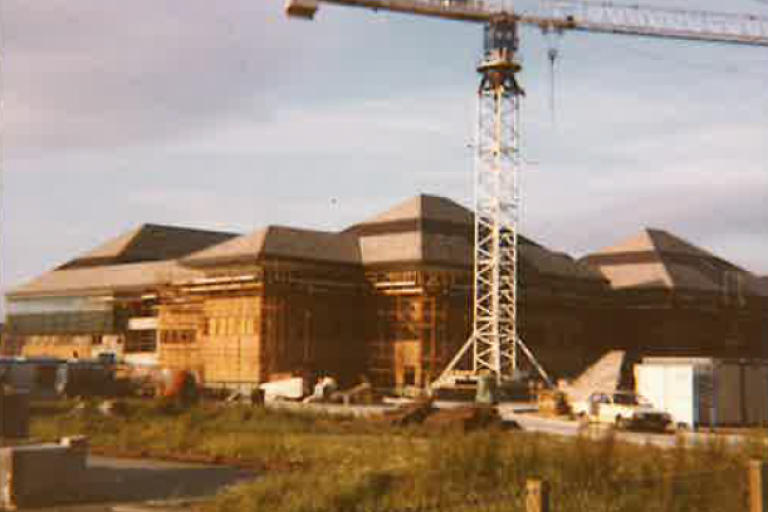 A landscape featuring hospital buildings with a crane in the foreground