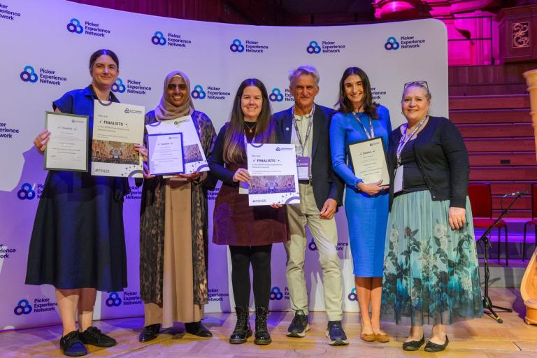 A group of six people smiling and holding up certificates