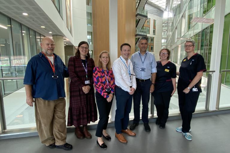 The cardiology and digital services project team are grouped together smiling in the Brunel Atrium at Southmead Hospital.