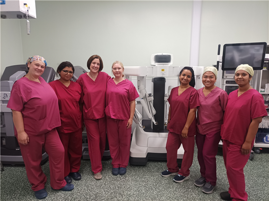 Group photo of UHBW surgical team next to surgical robot