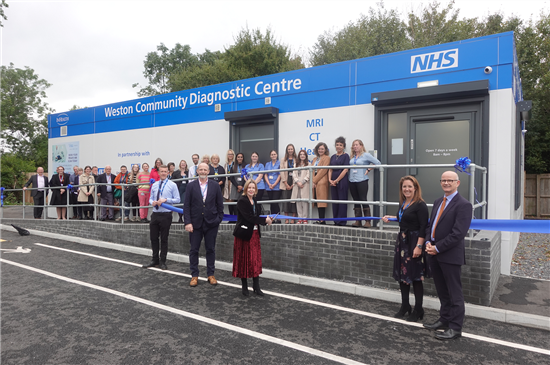 Staff pose outside Weston Community Diagnostic Centre for the ribbon cutting, with balloons