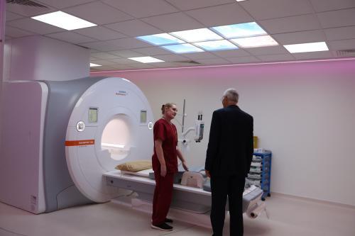Two medical professionals standing in front of a MRI scanner
