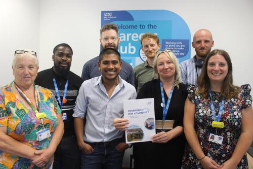"Commitment to Our Community" team smile for group photo at launch event