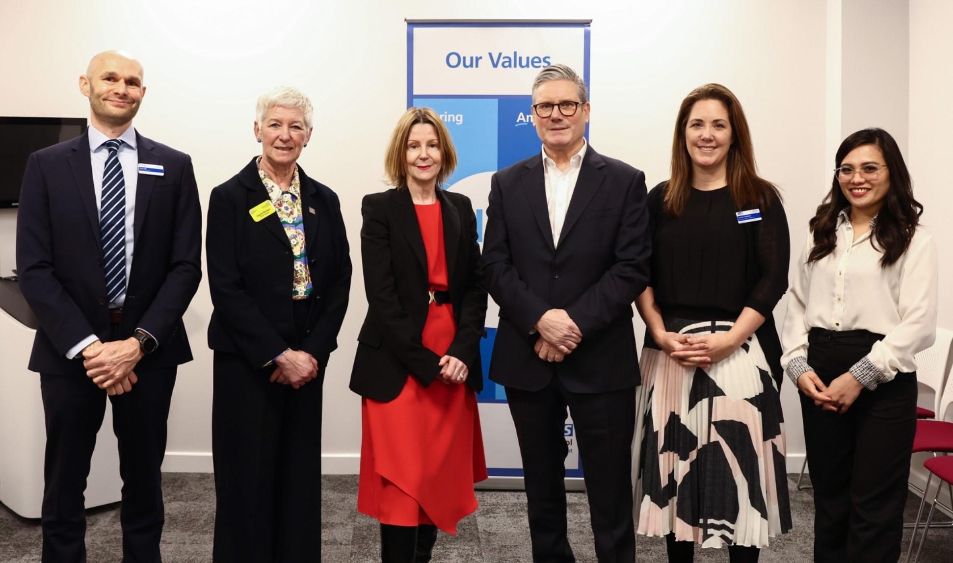 Prime Minister Keir Starmer smiles in group photo with Maria Kane, Ingrid Barker and InHealth team