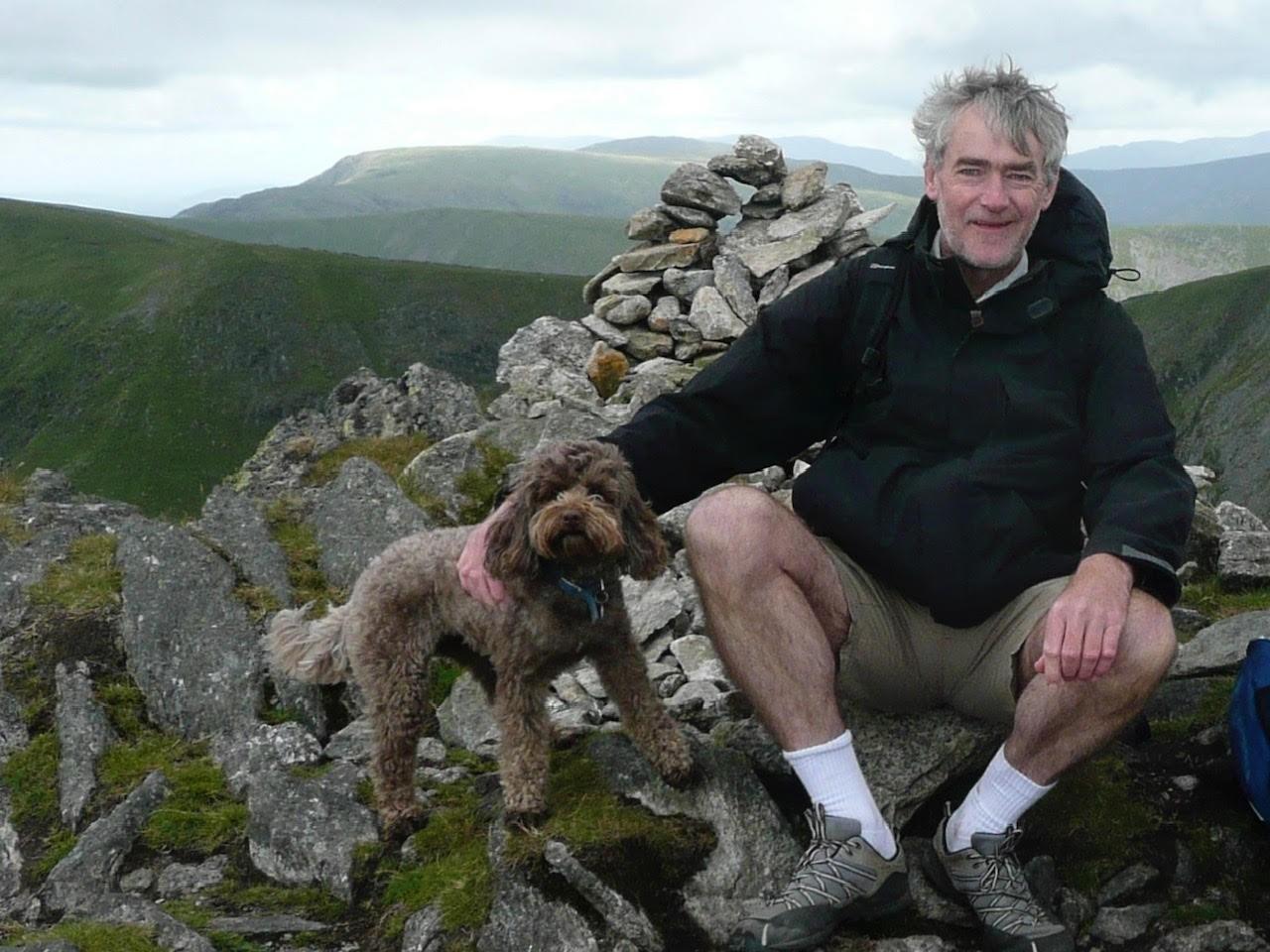 Duncan, who volunteered for the Nova trial, sits on a dry stone wall with his dog
