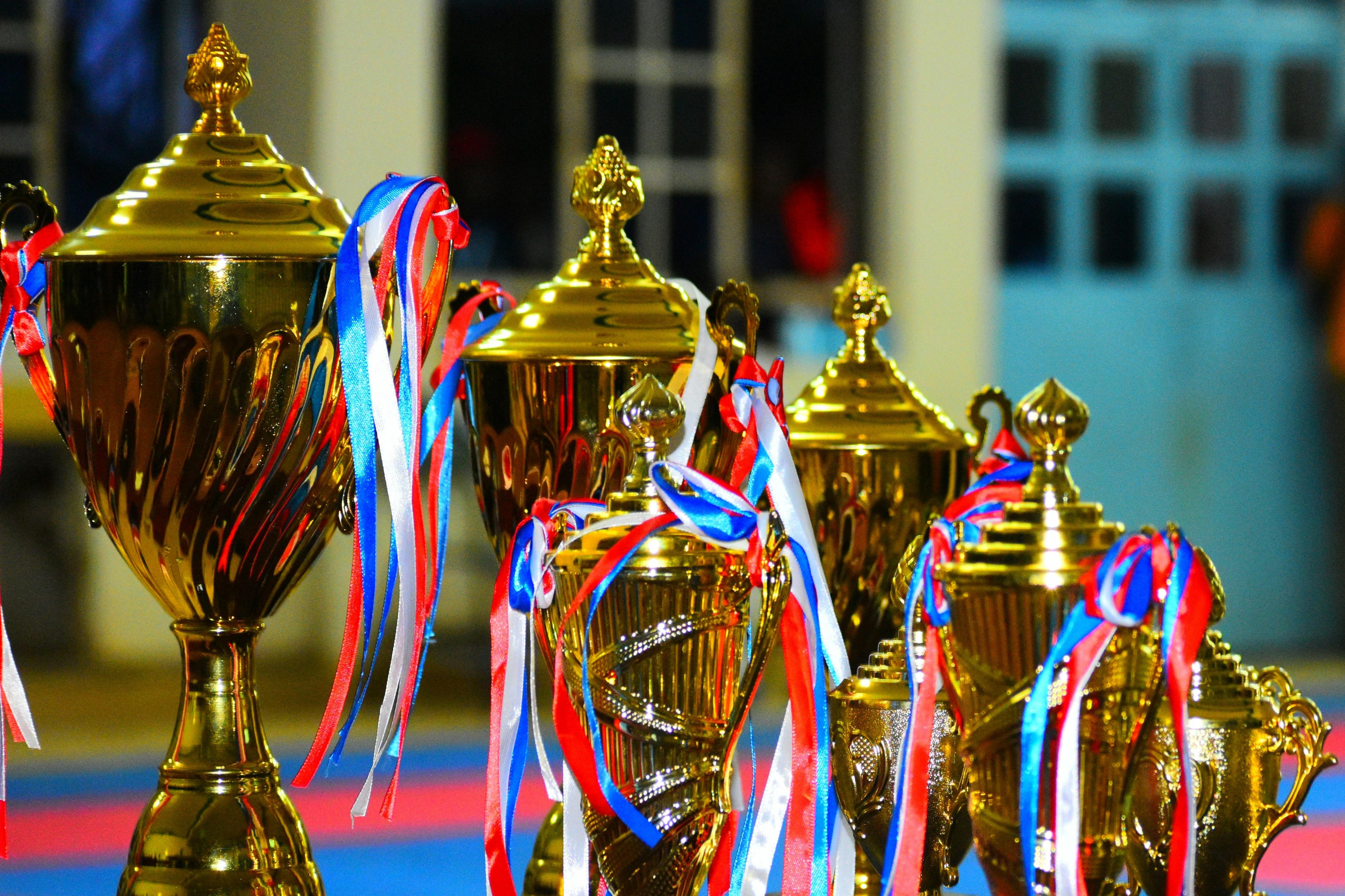 A row of gold trophies with ribbons